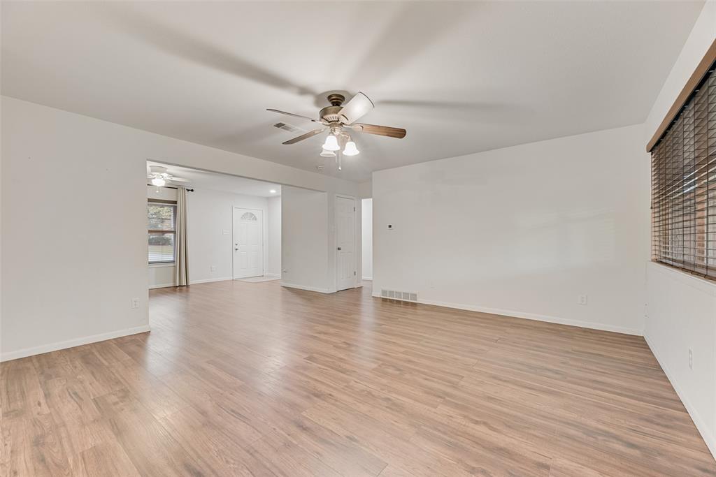1017 Calcutta Street Hurst, TX 76053 - Photo 2 of 18 a view of an empty room with wooden floor and a ceiling fan