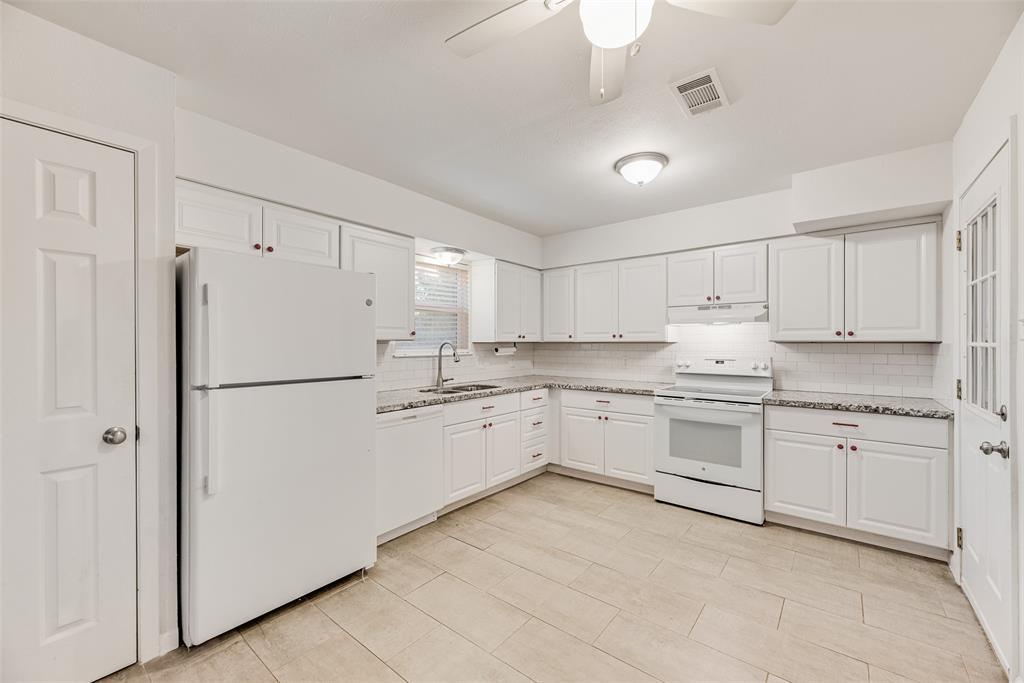 1017 Calcutta Street Hurst, TX 76053 - Photo 6 of 18 a kitchen with granite countertop cabinets and white appliances