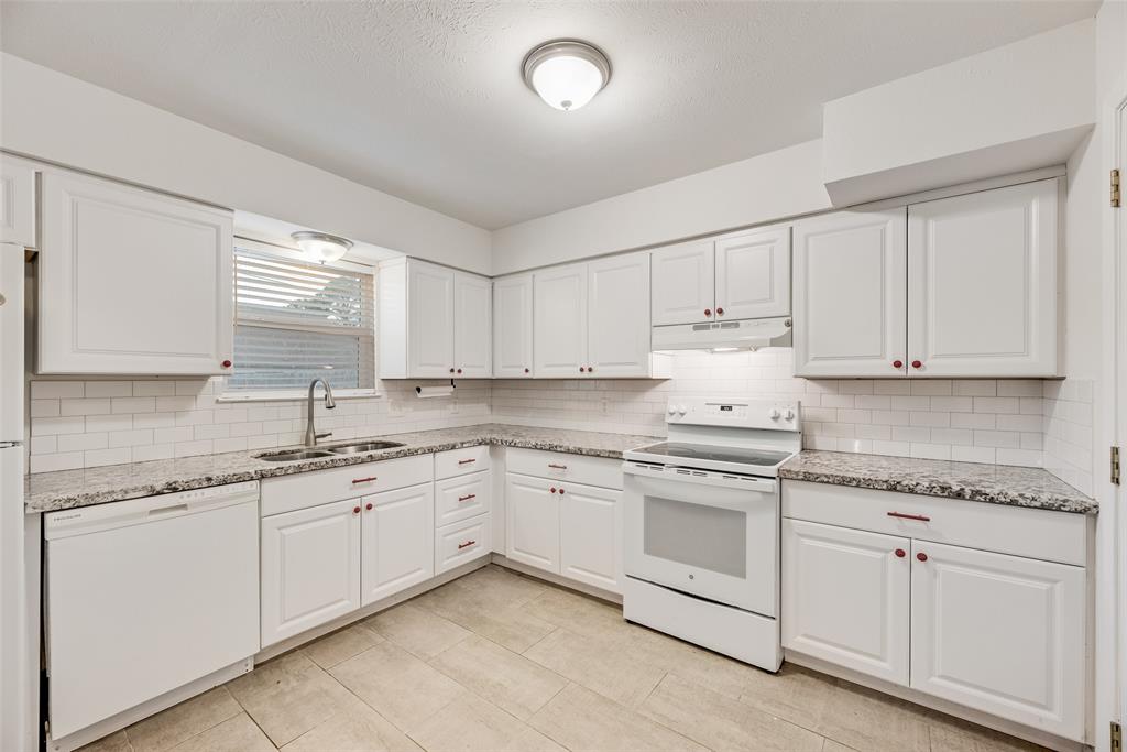 1017 Calcutta Street Hurst, TX 76053 - Photo 7 of 18 a kitchen with granite countertop white cabinets and white stainless steel appliances