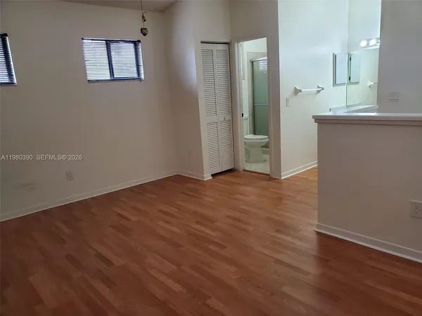 an empty room with wooden floor and a mirror