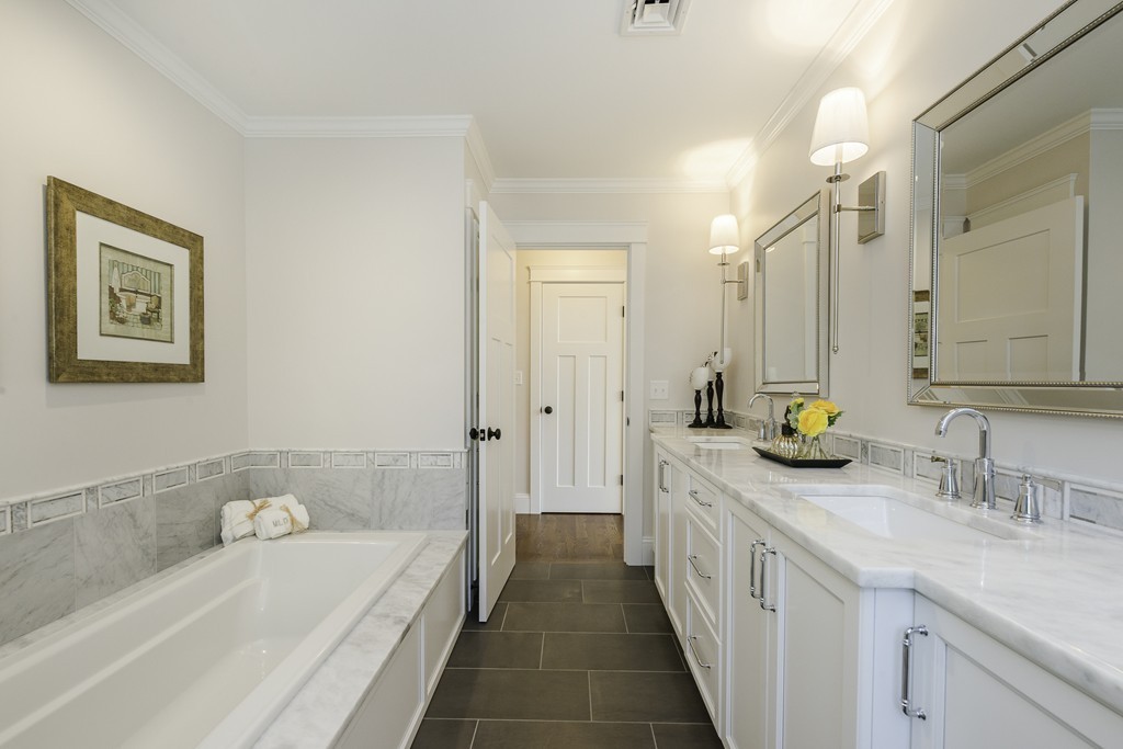 19 Hinds Road Winchester, MA 01890 - Photo 22 of 29 a bathroom with a double vanity sink a mirror a bathtub and next to a window