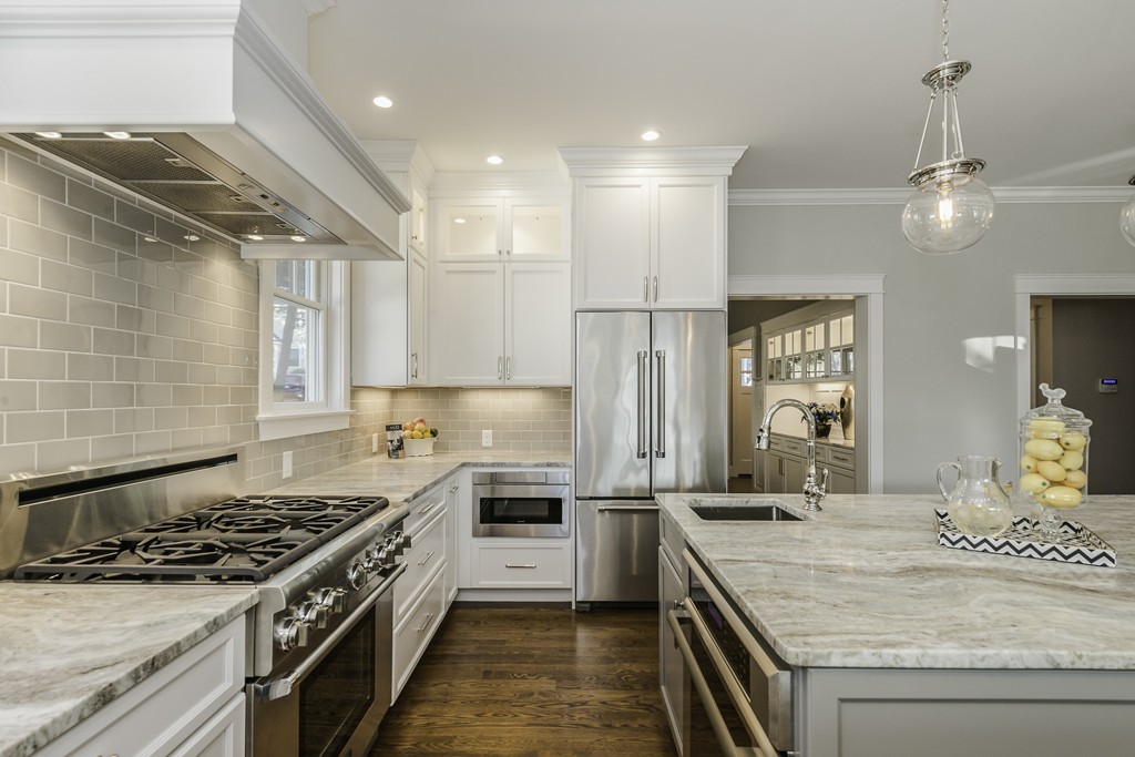 19 Hinds Road Winchester, MA 01890 - Photo 9 of 29 a kitchen with stainless steel appliances granite countertop a stove a sink dishwasher a refrigerator and white cabinets with wooden floor