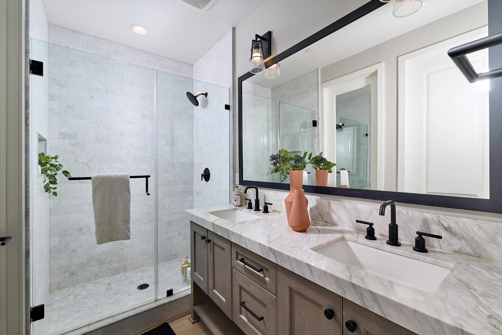 1601 San Remo Place, Unit 101 Encinitas, CA 92024 - Photo 13 of 27 a bathroom with a granite countertop sink a mirror and shower