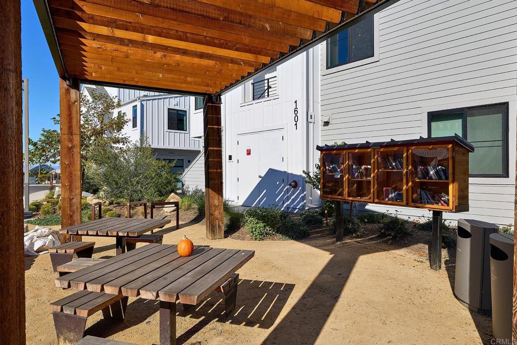 1601 San Remo Place, Unit 101 Encinitas, CA 92024 - Photo 14 of 27 a view of a patio with table and chairs with wooden floor and fence