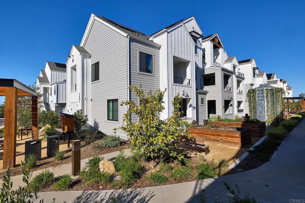 1601 San Remo Place, Unit 101 Encinitas, CA 92024 - Photo 15 of 27 a view of a white house with many windows next to a yard