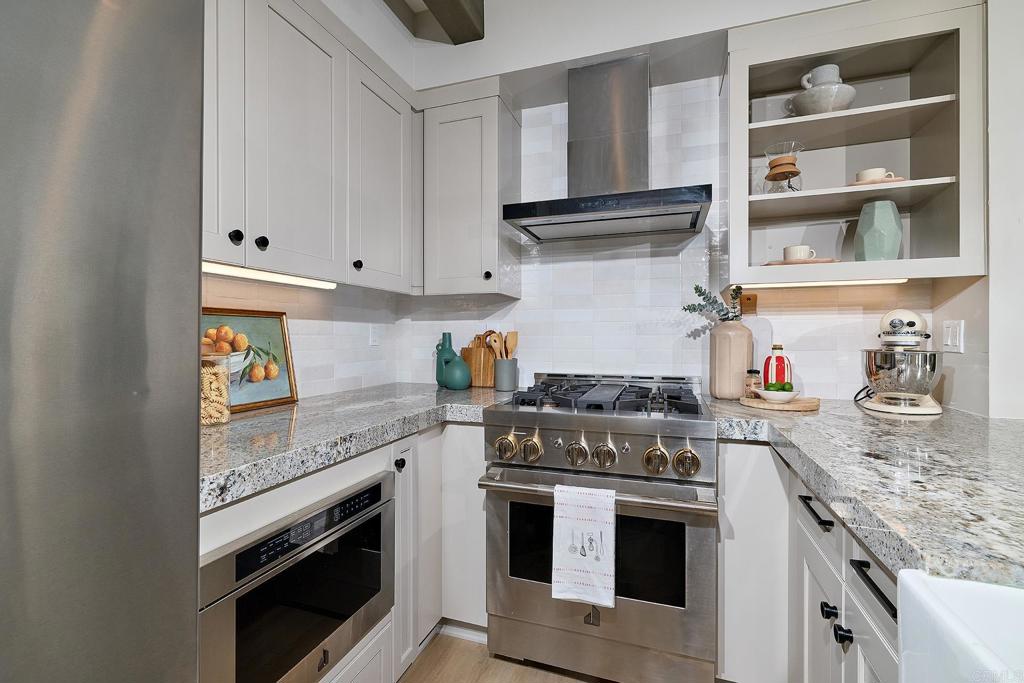 1601 San Remo Place, Unit 101 Encinitas, CA 92024 - Photo 7 of 27 a kitchen with stainless steel appliances granite countertop a stove and cabinets