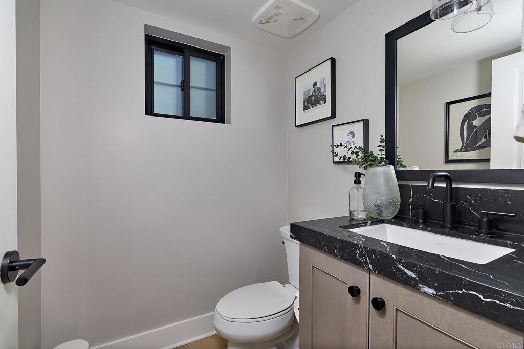 1601 San Remo Place, Unit 101 Encinitas, CA 92024 - Photo 10 of 27 a bathroom with a granite countertop sink vanity mirror and toilet