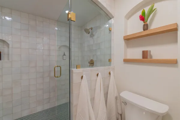 a bathroom with a shower a toilet and sink