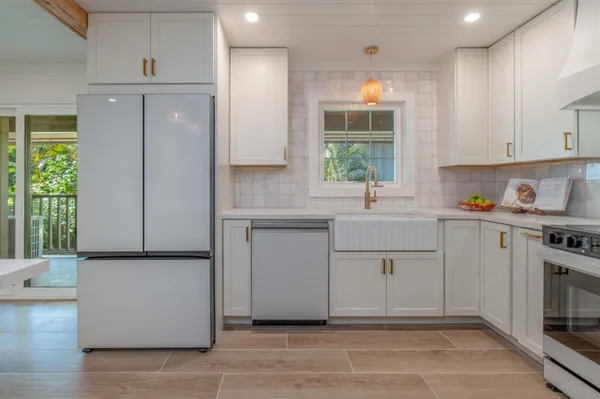 a kitchen with a refrigerator and white cabinets
