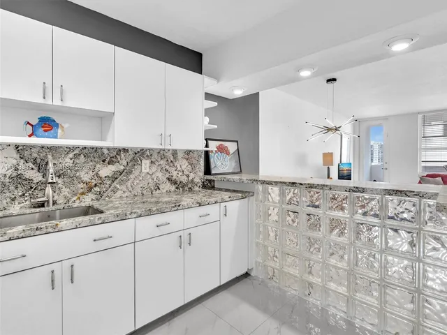 a kitchen with granite countertop white cabinets and white appliances