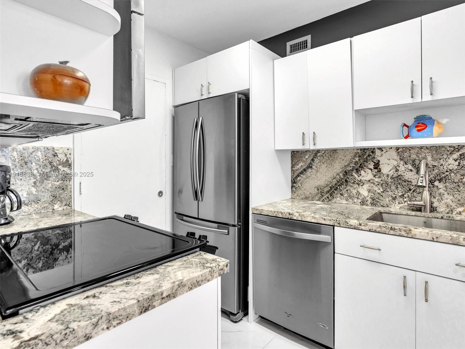 100 Lincoln Road, Unit 710 Miami Beach, FL 33139 - Photo 14 of 36 a kitchen with stainless steel appliances granite countertop a sink and a refrigerator