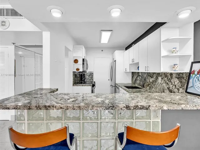 a kitchen with stainless steel appliances granite countertop a sink and cabinets