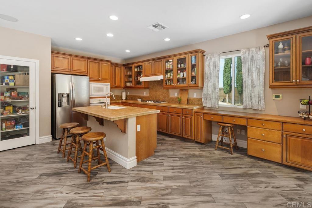 44684 Mumm Street Temecula, CA 92592 - Photo 15 of 51 a kitchen with stainless steel appliances granite countertop a sink counter space and wooden floor