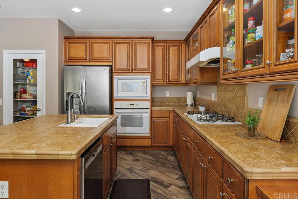 44684 Mumm Street Temecula, CA 92592 - Photo 16 of 51 a kitchen with granite countertop a sink stove and refrigerator