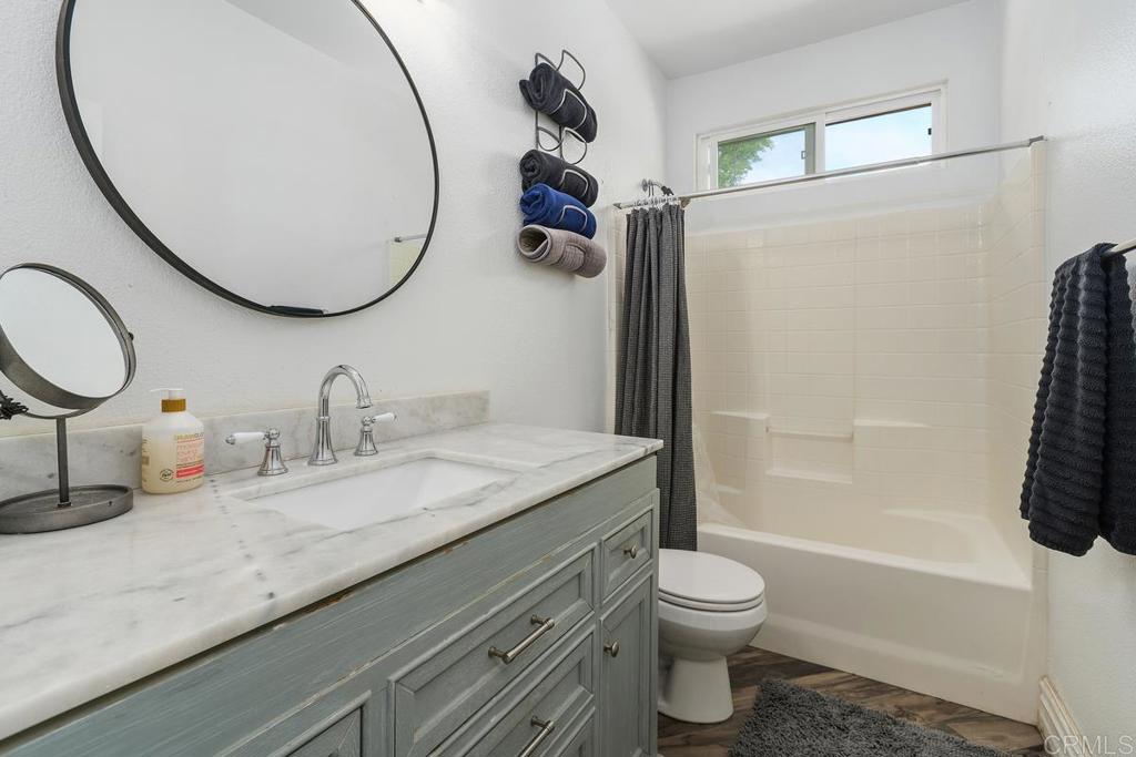 44684 Mumm Street Temecula, CA 92592 - Photo 23 of 51 a bathroom with a granite countertop sink toilet mirror vanity and shower