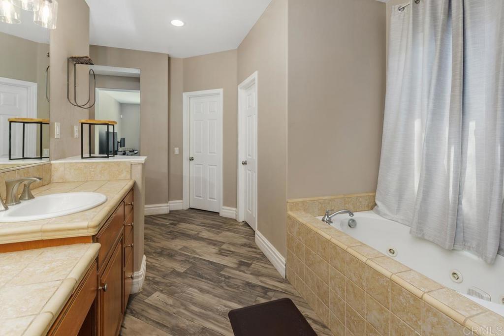 44684 Mumm Street Temecula, CA 92592 - Photo 28 of 51 a bathroom with a tub sink and mirror