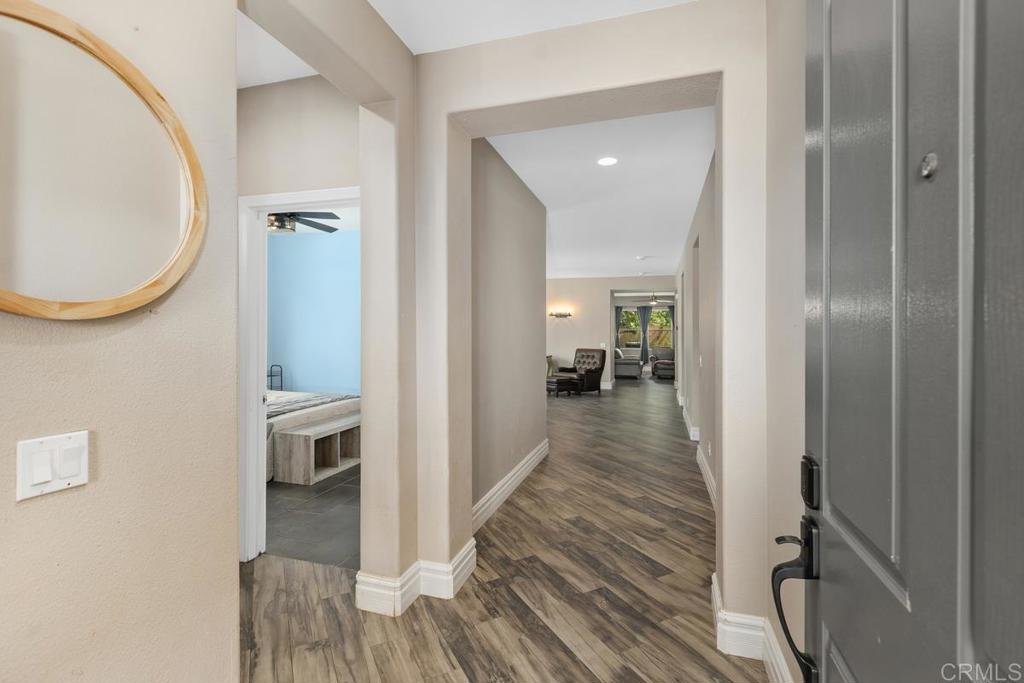 44684 Mumm Street Temecula, CA 92592 - Photo 5 of 51 a view of a hallway with wooden floor and a living room