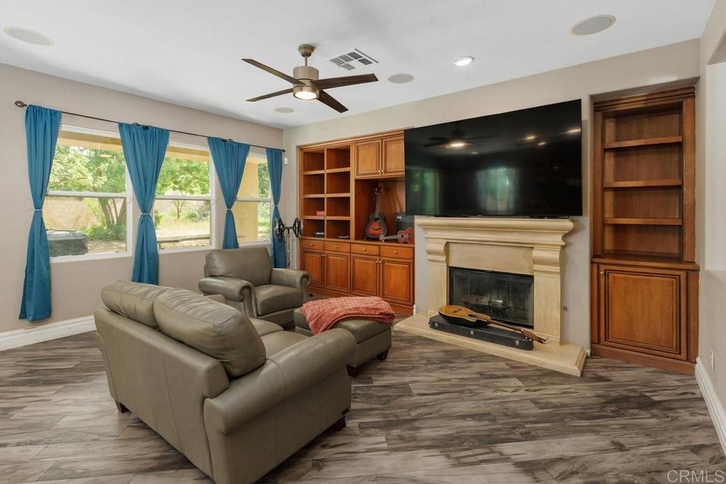 44684 Mumm Street Temecula, CA 92592 - Photo 9 of 51 a living room with furniture a flat screen tv and a fireplace