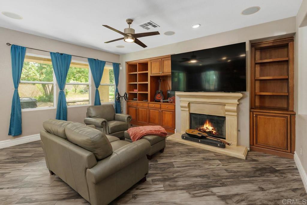 44684 Mumm Street Temecula, CA 92592 - Photo 10 of 51 a living room with furniture a flat screen tv and a fireplace