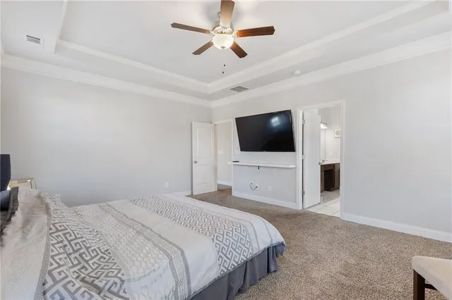 a bedroom with a bed tv tv and a ceiling fan