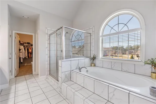 a bathroom with a granite countertop sink a mirror and a bathtub