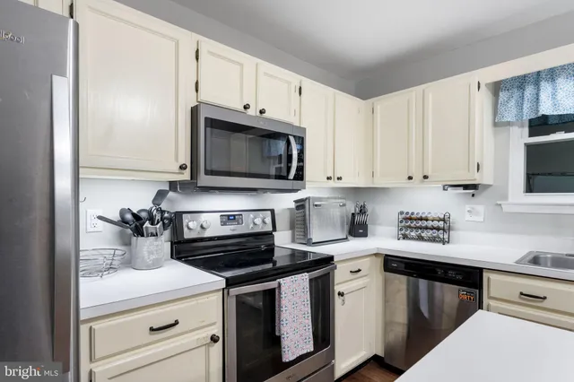 a kitchen with appliances a sink and cabinets