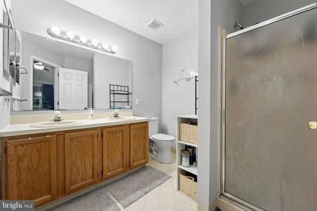 a spacious bathroom with a double vanity sink toilet and shower