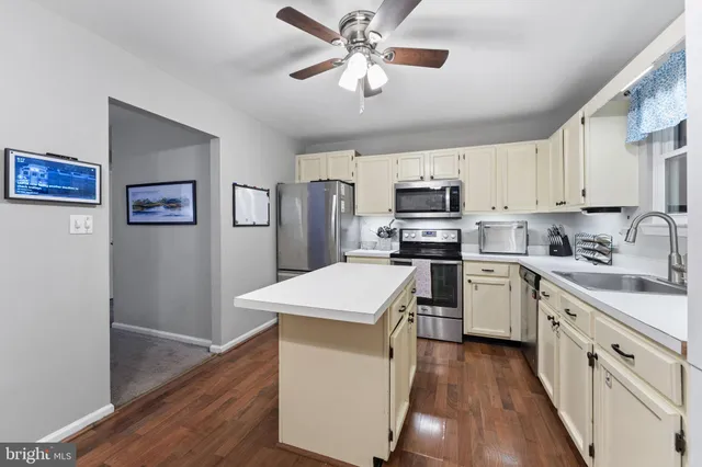 a kitchen with granite countertop a refrigerator stove top oven and cabinets