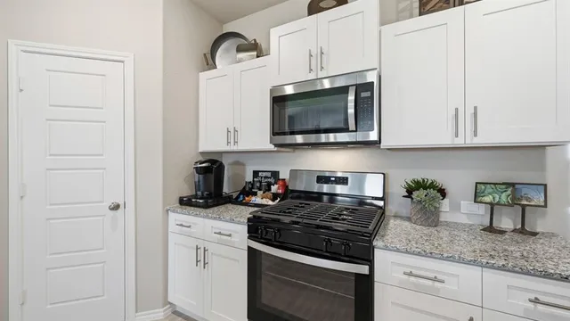 a kitchen with stainless steel appliances granite countertop a stove a sink and a refrigerator
