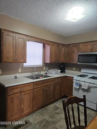 a kitchen with sink a stove and cabinets