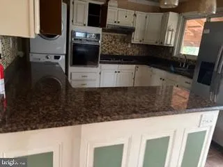 a kitchen with stainless steel appliances a sink a stove a microwave a sink and cabinets