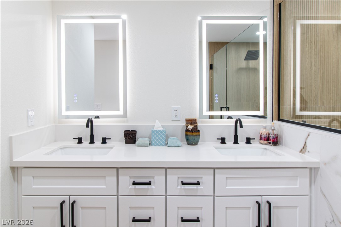 1891 Brian Road Pahrump, NV 89048 - Photo 18 of 50 Full bath featuring double vanity, a shower with shower door, and a sink