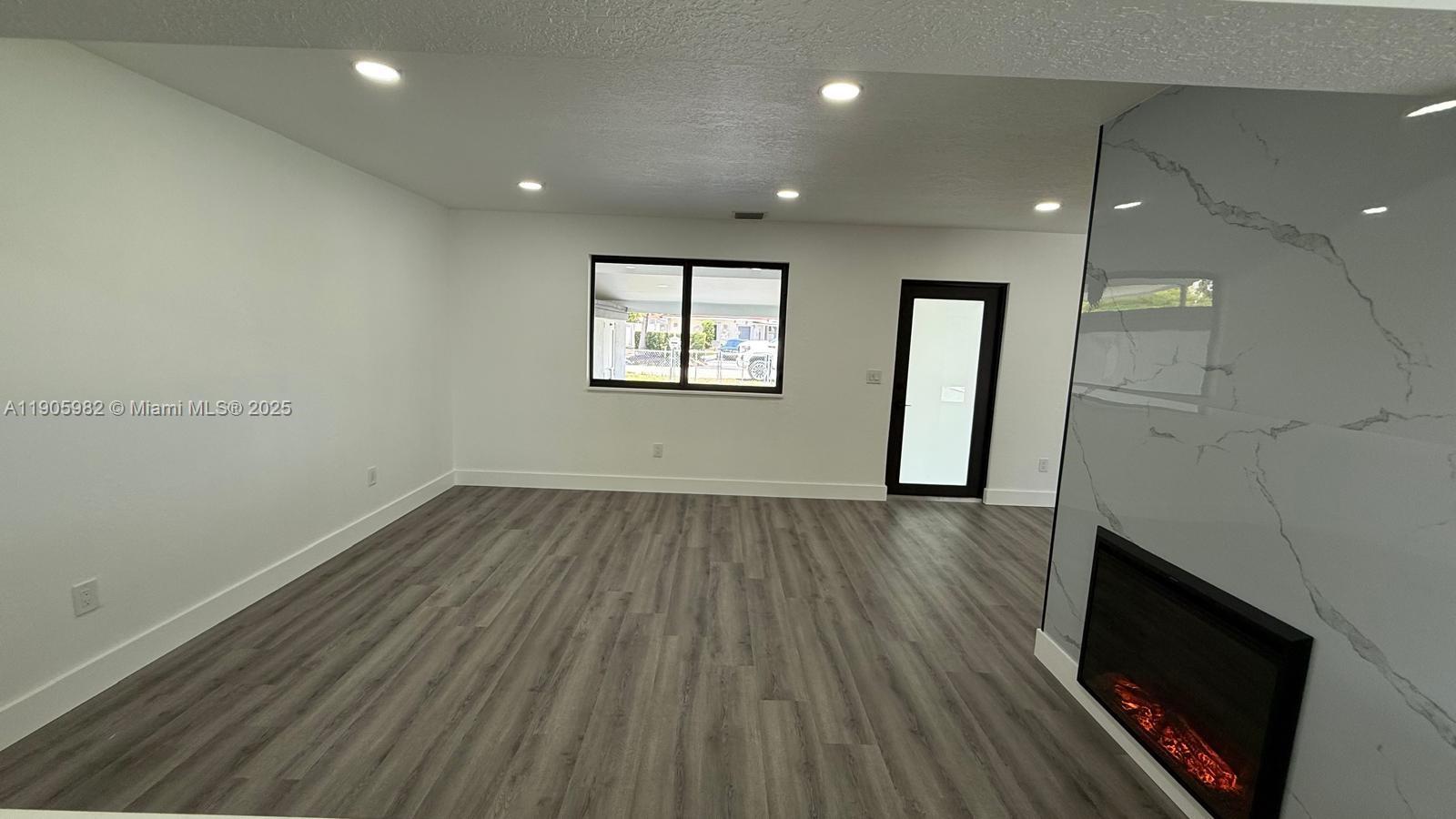 20 Northwest 197th Street Miami Gardens, FL 33169 - Photo 13 of 48 an empty room with wooden floor and windows