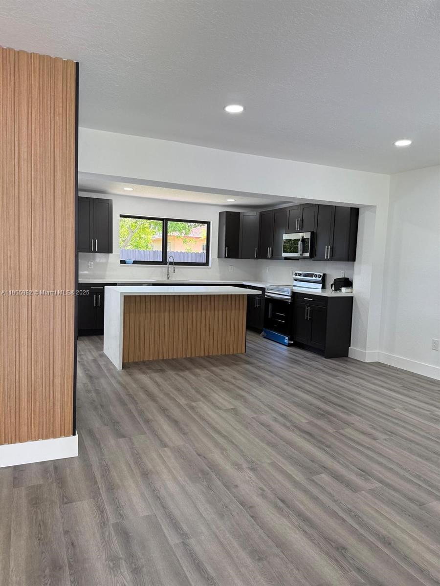20 Northwest 197th Street Miami Gardens, FL 33169 - Photo 16 of 48 a view of kitchen with stainless steel appliances granite countertop a sink and dishwasher a stove top oven with wooden floor