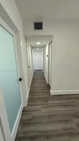 a view of a hallway with wooden floor
