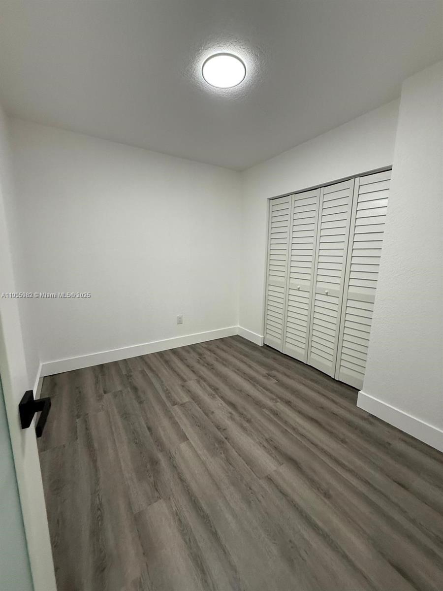 20 Northwest 197th Street Miami Gardens, FL 33169 - Photo 28 of 48 an empty room with wooden floor and windows