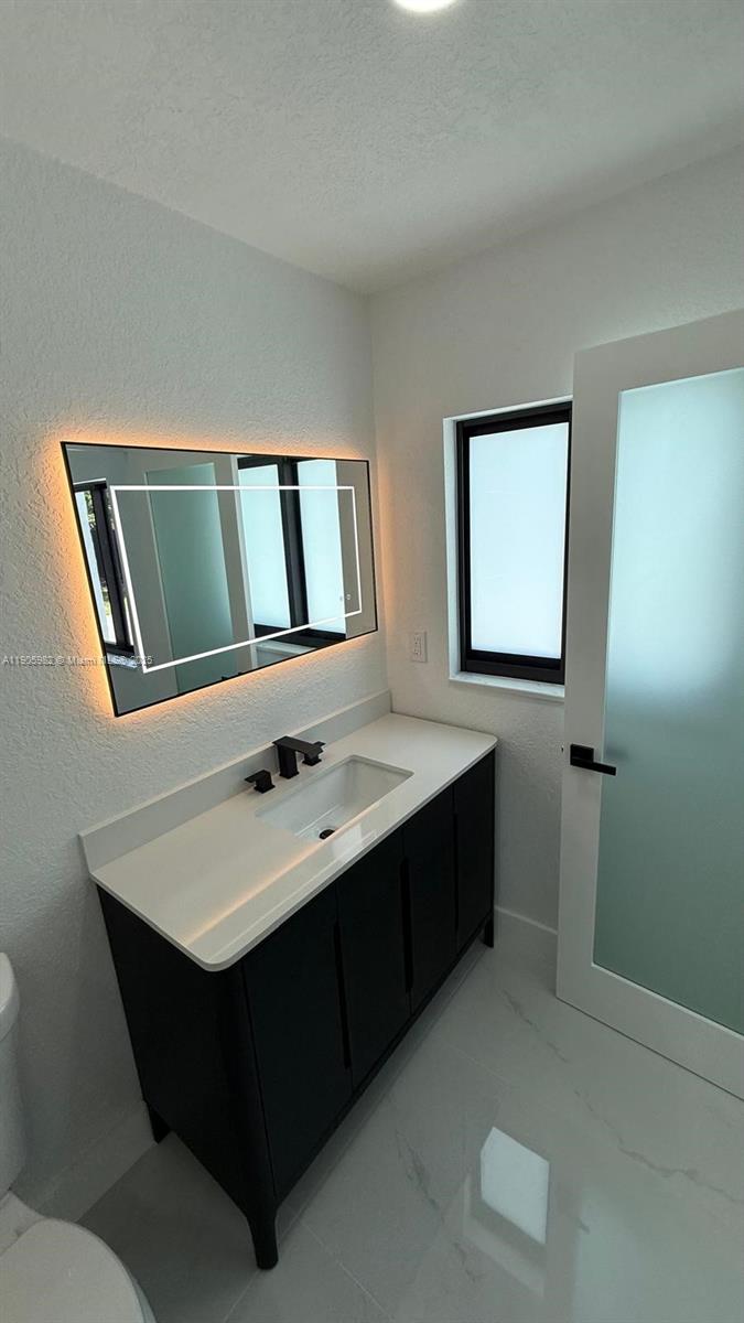 20 Northwest 197th Street Miami Gardens, FL 33169 - Photo 38 of 48 a bathroom with a sink and a mirror