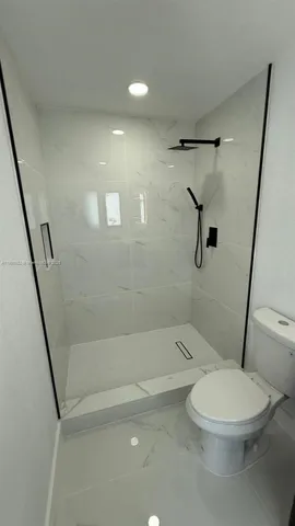 a white toilet sitting next to a bath tub