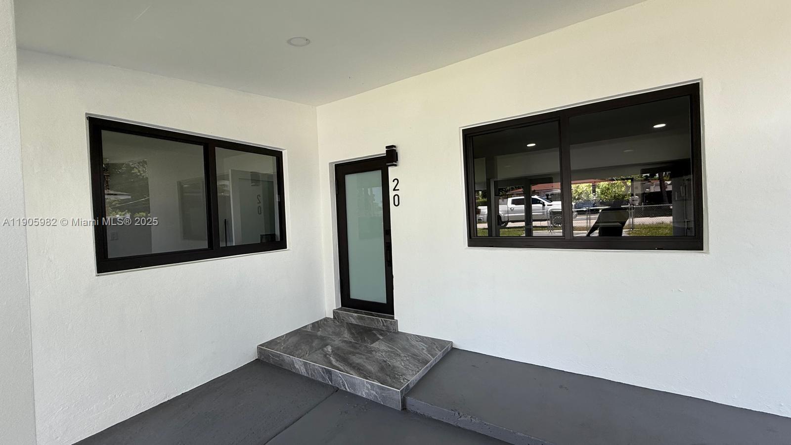 20 Northwest 197th Street Miami Gardens, FL 33169 - Photo 5 of 48 a hallway with a large mirror and door