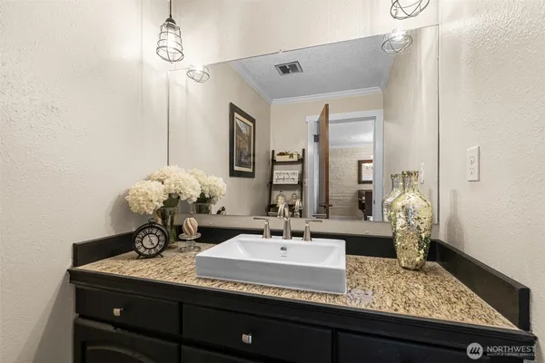 a bathroom with a granite countertop sink and a mirror