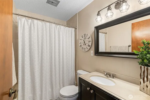 a bathroom with a sink vanity mirror and toilet