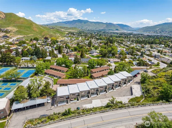 an aerial view of residential houses with outdoor space and parking