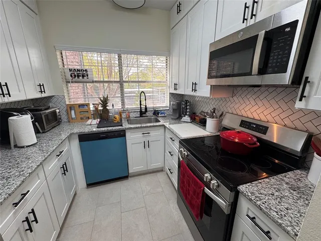a kitchen with a stove sink and microwave