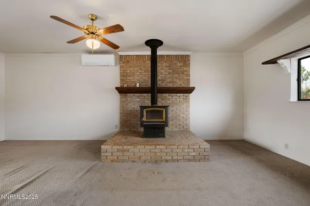 an empty room with a chandelier fan and a window