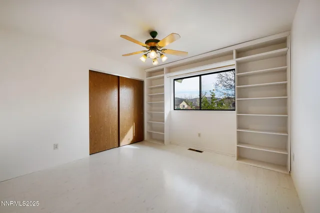 a view of an empty room with a chandelier fan