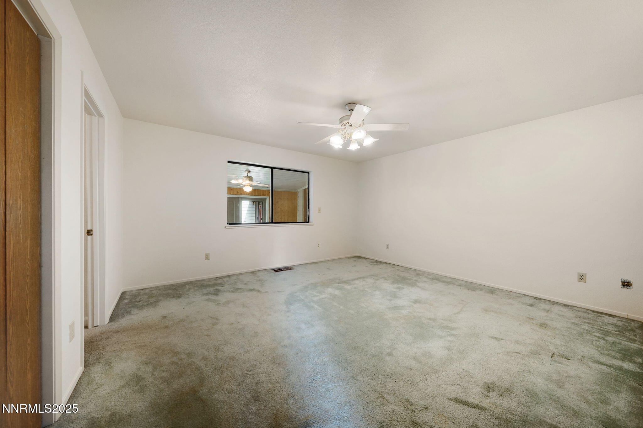 450 Marsh Road Carson City, NV 89701 - Photo 32 of 41 an empty room with a chandelier fan and windows