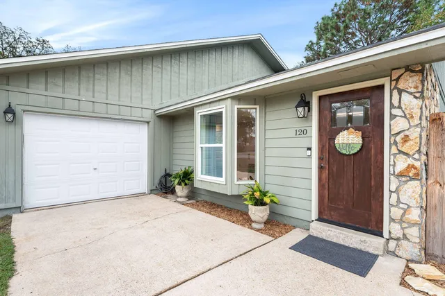 a front view of a house with potted plants