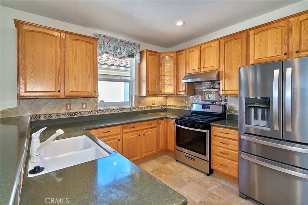 1143 Saguara Road Beaumont, CA 92223 - Photo 39 of 66 a kitchen with stainless steel appliances granite countertop a refrigerator a stove and a sink