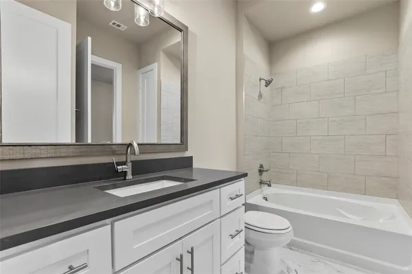 a bathroom with a bathtub a sink a toilet and a mirror