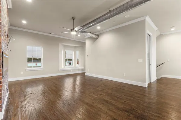 a view of kitchen with stainless steel appliances granite countertop wooden cabinets and a wooden floor